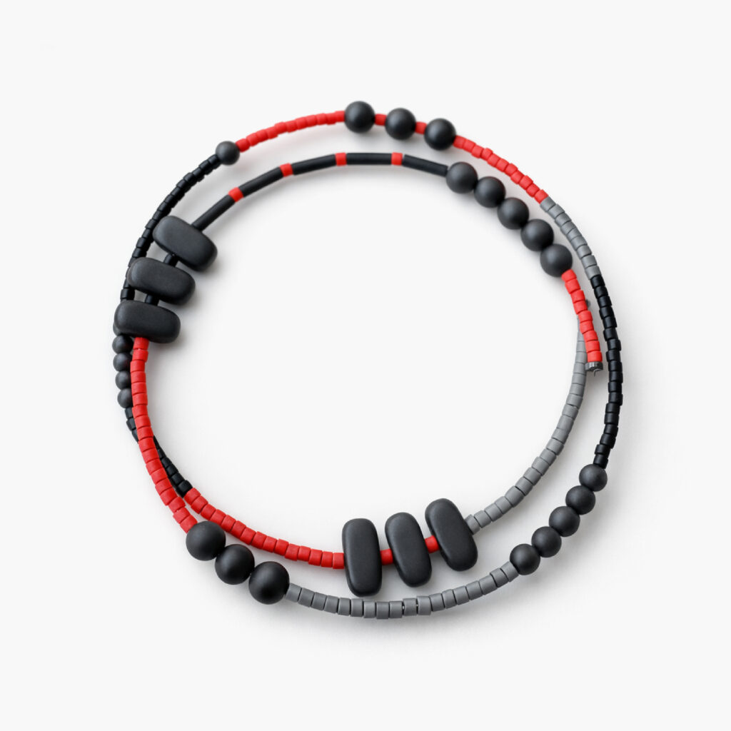 Red black and grey memory wire bracelet on white background