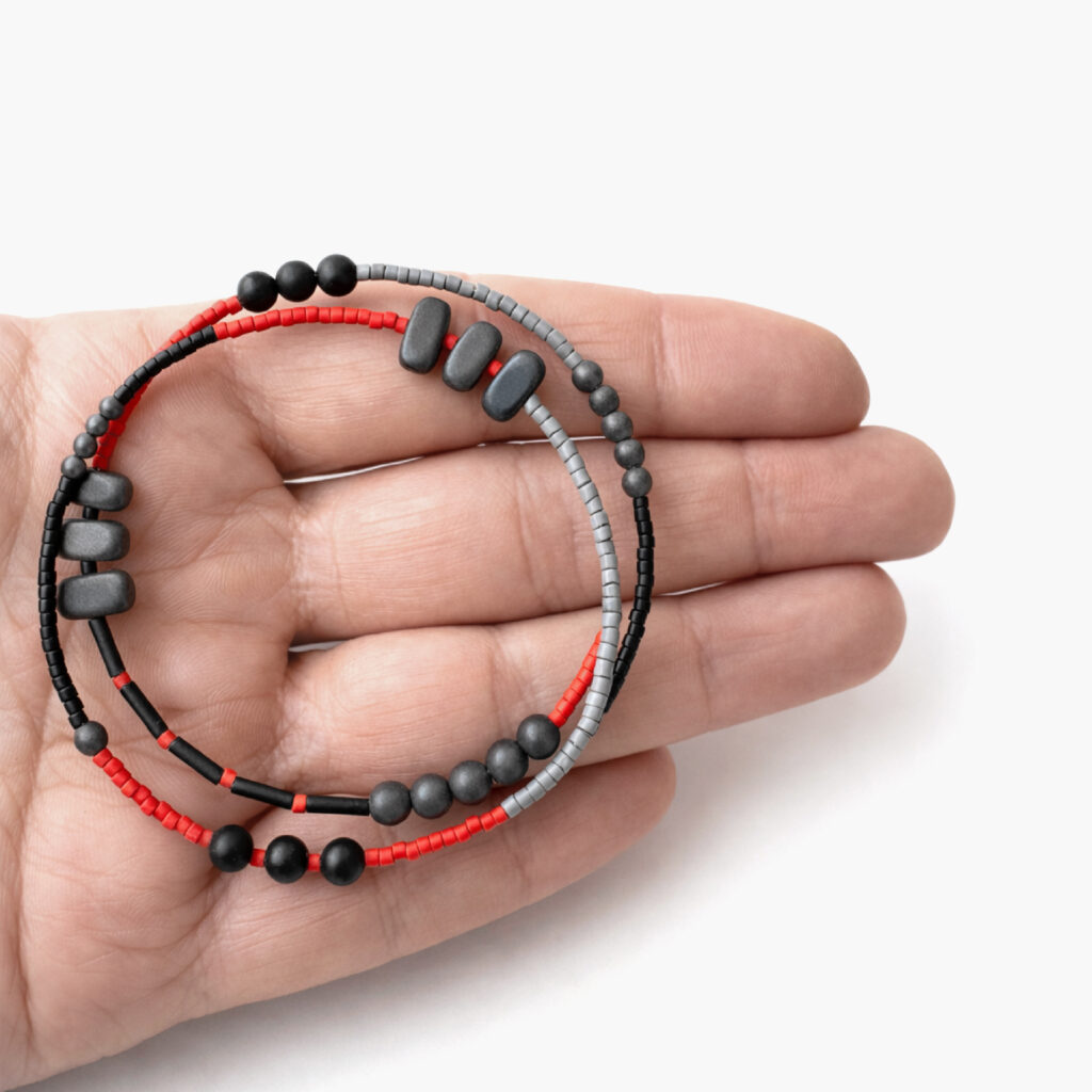 Red black and grey memory wire bracelet shown in hand