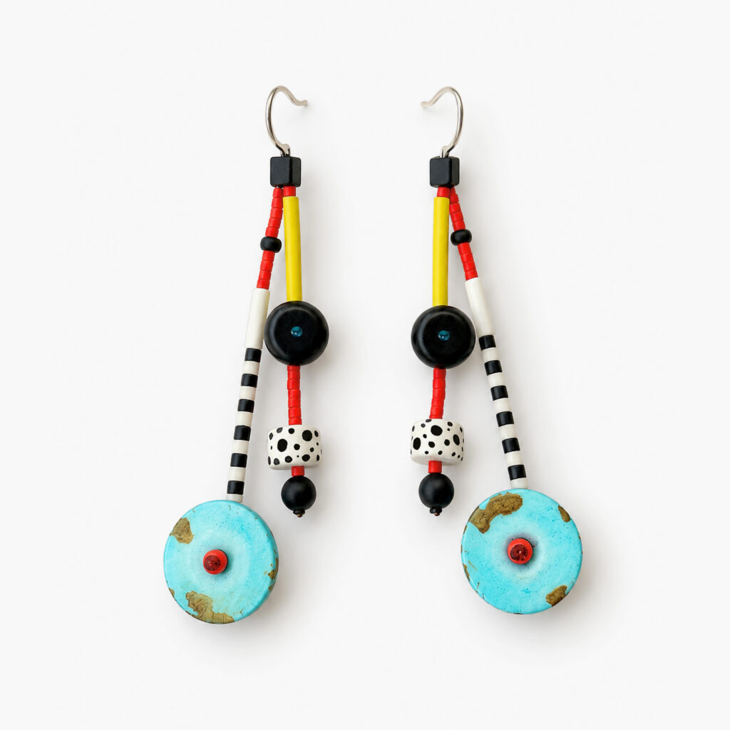 Turquoise beaded earrings with red, yellow, black-and-white patterned details on a white background