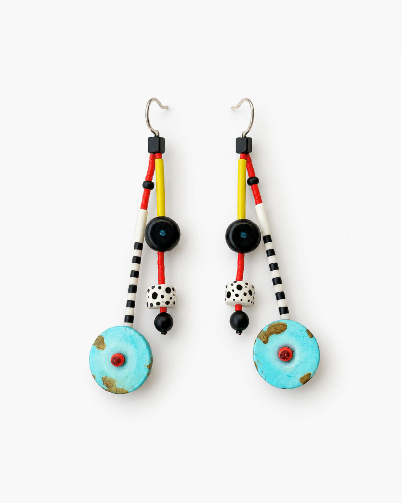 Turquoise geometric beaded earrings with red, yellow, black-and-white patterned details on a white background