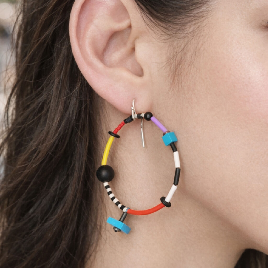 Colorful beaded hoop earrings worn on ear