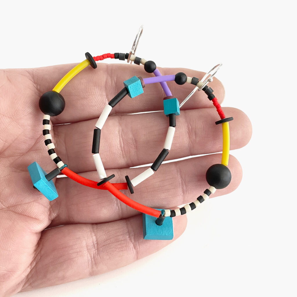 Colorful beaded hoop earrings shown in hand