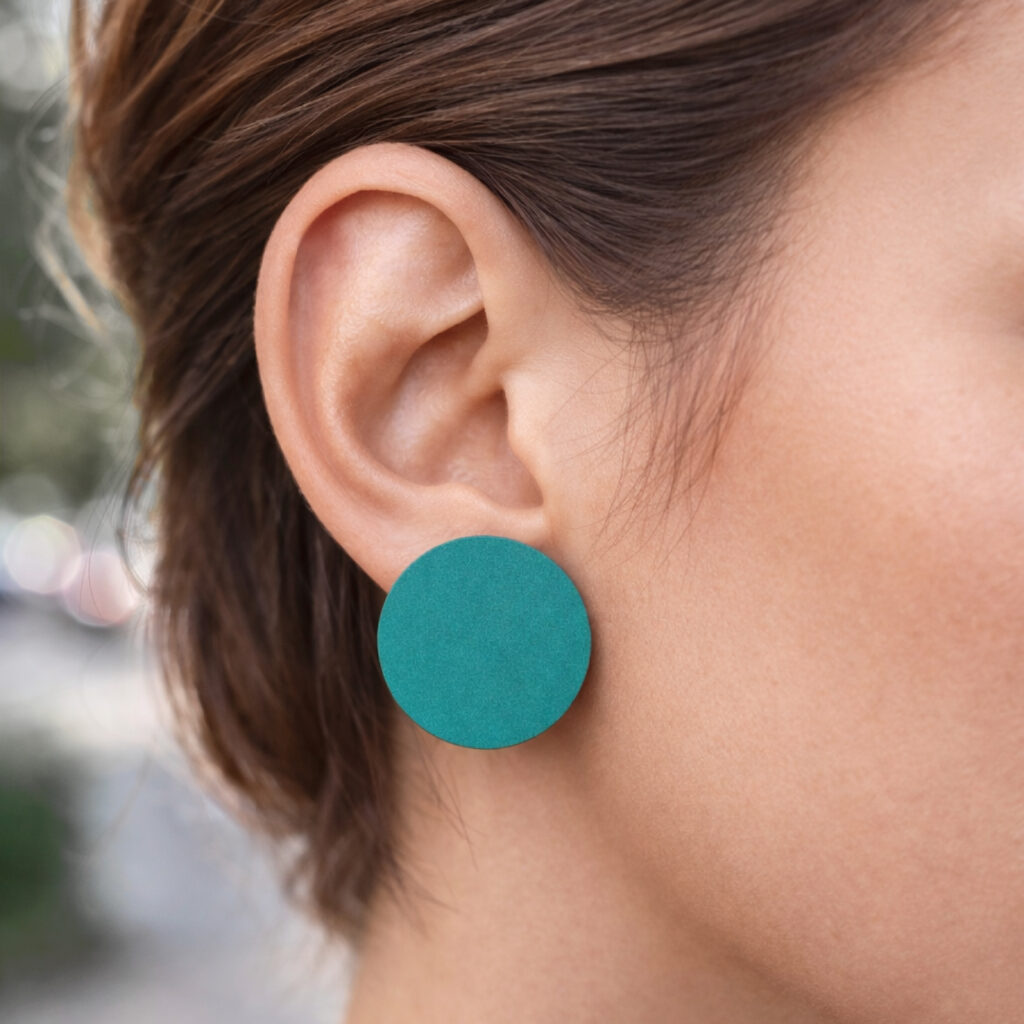 Large petrol round wooden stud earrings worn on ear