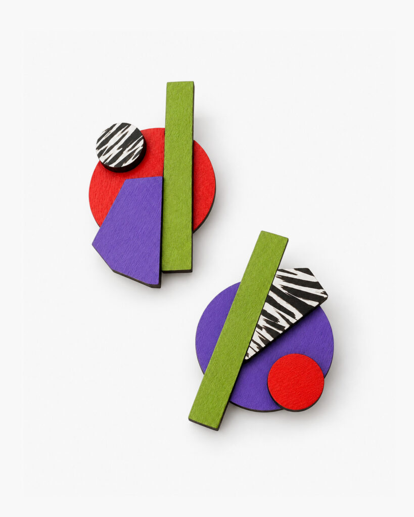 Mismatched wooden earrings showing contrasting geometric compositions on a white background