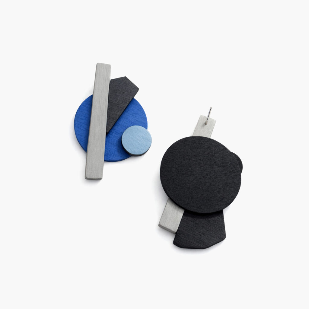 Asymmetrical blue and black wooden earrings showing front and back views