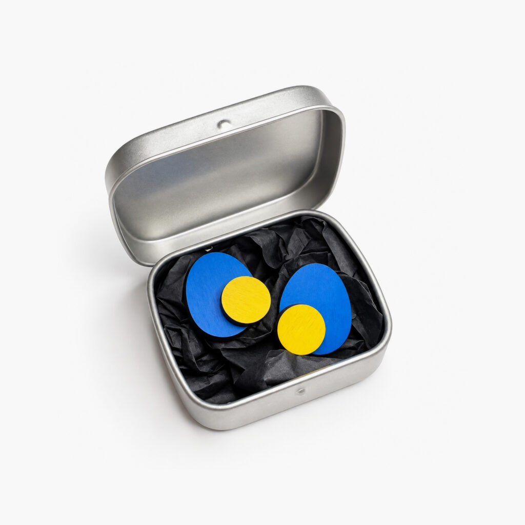 Blue and yellow geometric stud earrings in a metal gift box