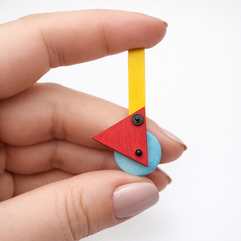 Colorful geometric wooden earring held in hand