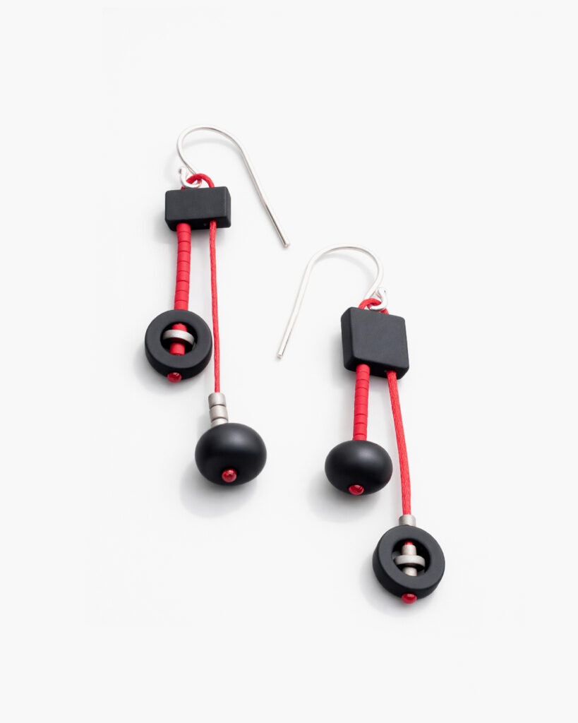 Asymmetrical black and red dangle earrings with contrasting geometric elements and silver hooks