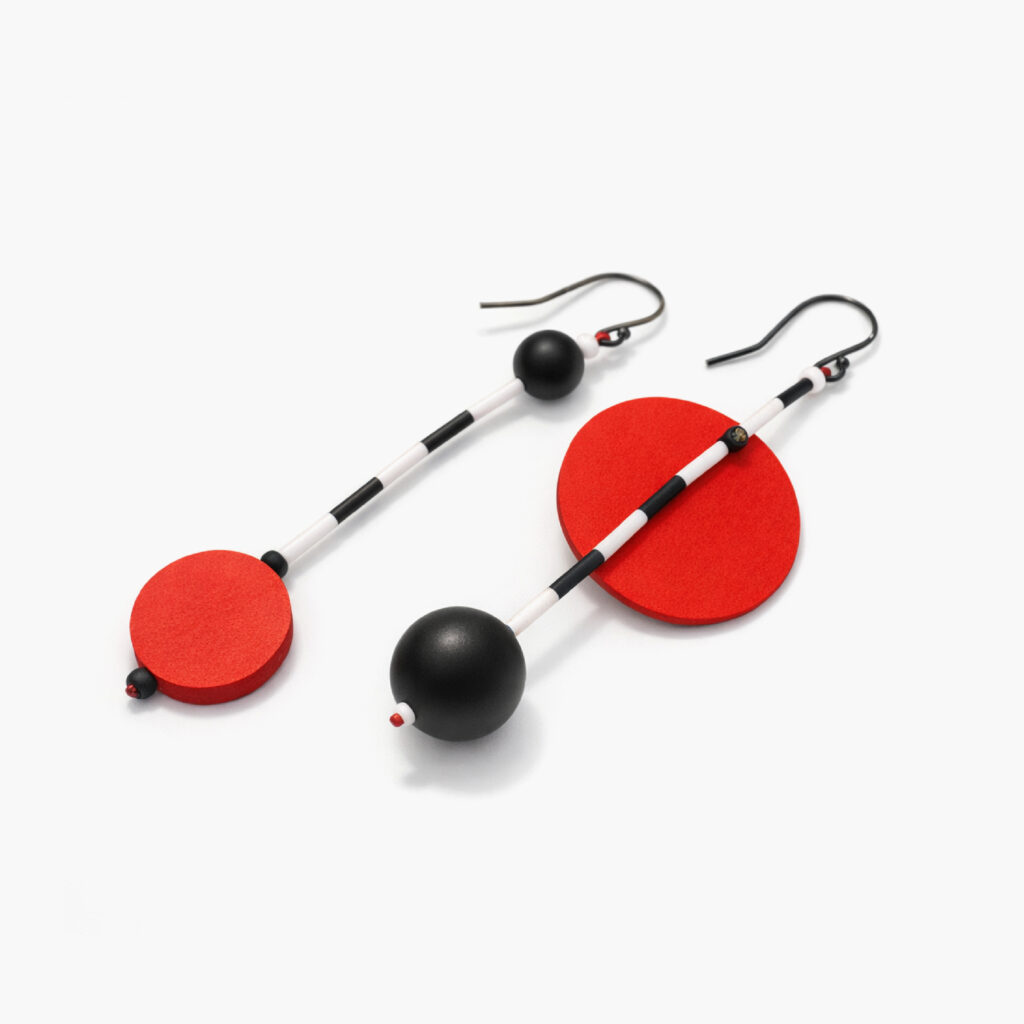 Red and black geometric dangle earrings with contrasting circular wooden shapes