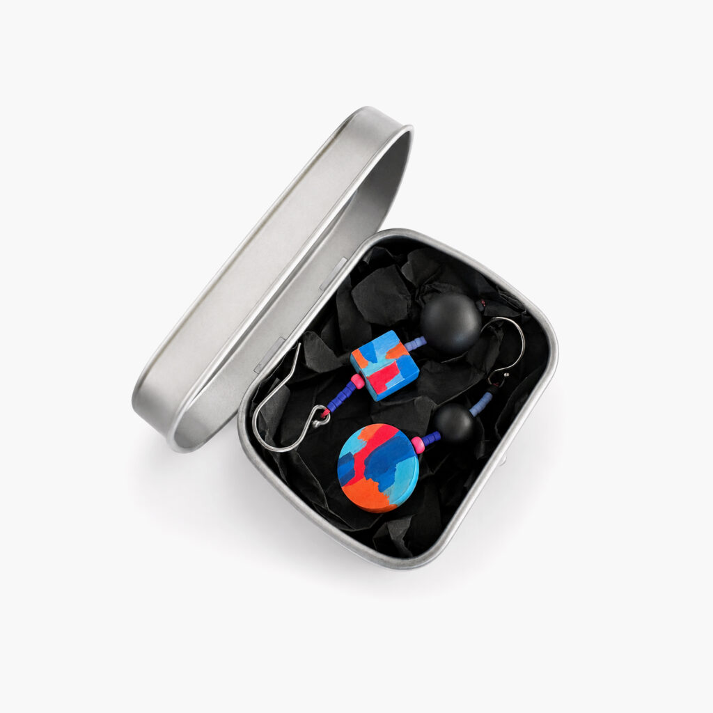 Colorful geometric dangle earring worn on ear with black round bead