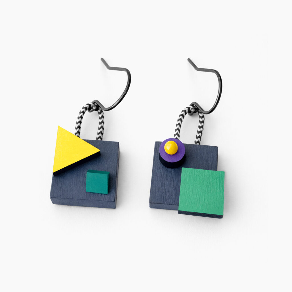 Colorful mismatched geometric wooden dangle earrings with layered shapes on a white background