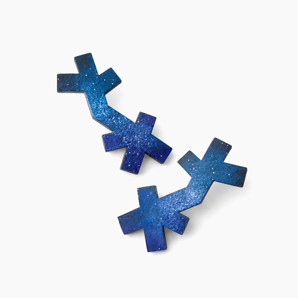 Blue abstract wooden stud earrings with textured geometric cross shapes