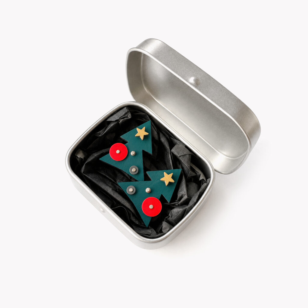 Green geometric Christmas tree stud earrings displayed in a metal gift box