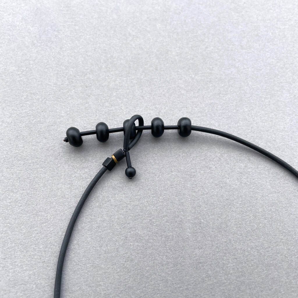 Adjustable black cord and sliding bead closure of industrial necklace