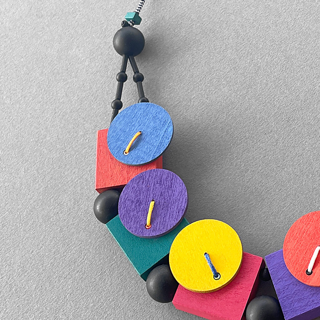 Multicolor geometric necklace with painted wood and black beads – close-up