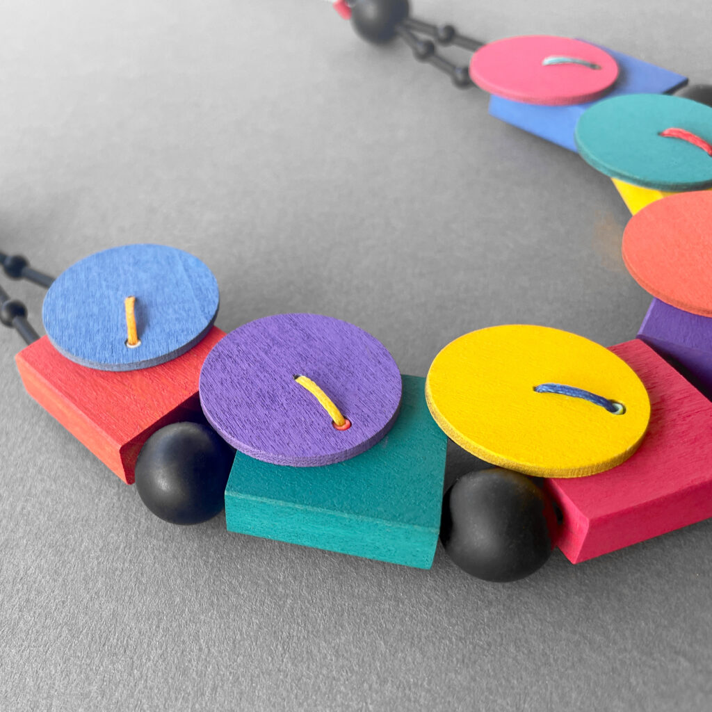 Multicolor geometric necklace with painted wood and black beads – close-up